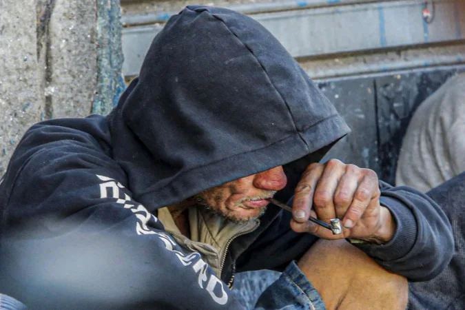 Pessoa segura um cigarro com substância entorpecente; imagem de arquivo sobre drogas