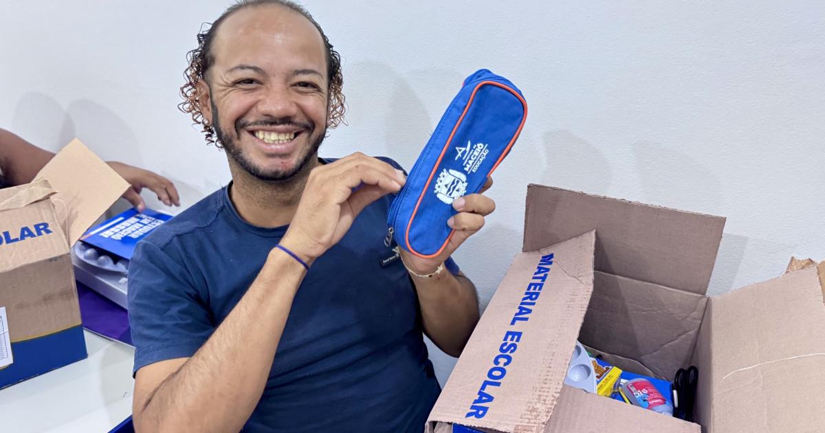 Aluno da Ejai no Centro Pop segura materiais escolares recebidos para as aulas
