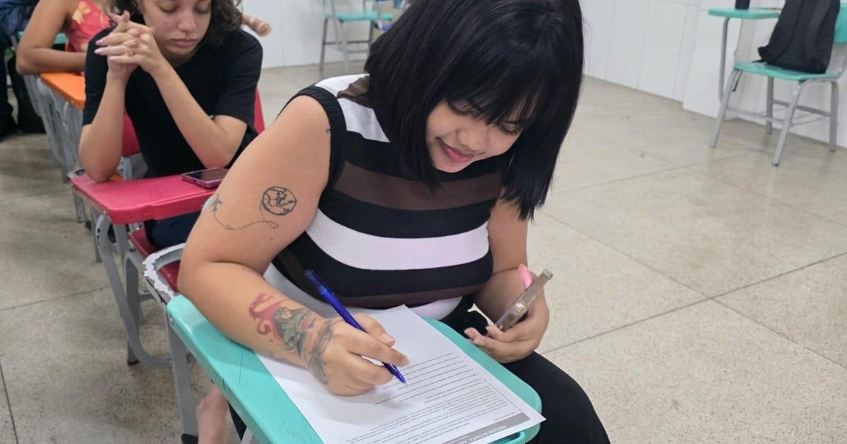 Aluna realiza atividade escrita em sala de aula do programa municipal de idiomas
