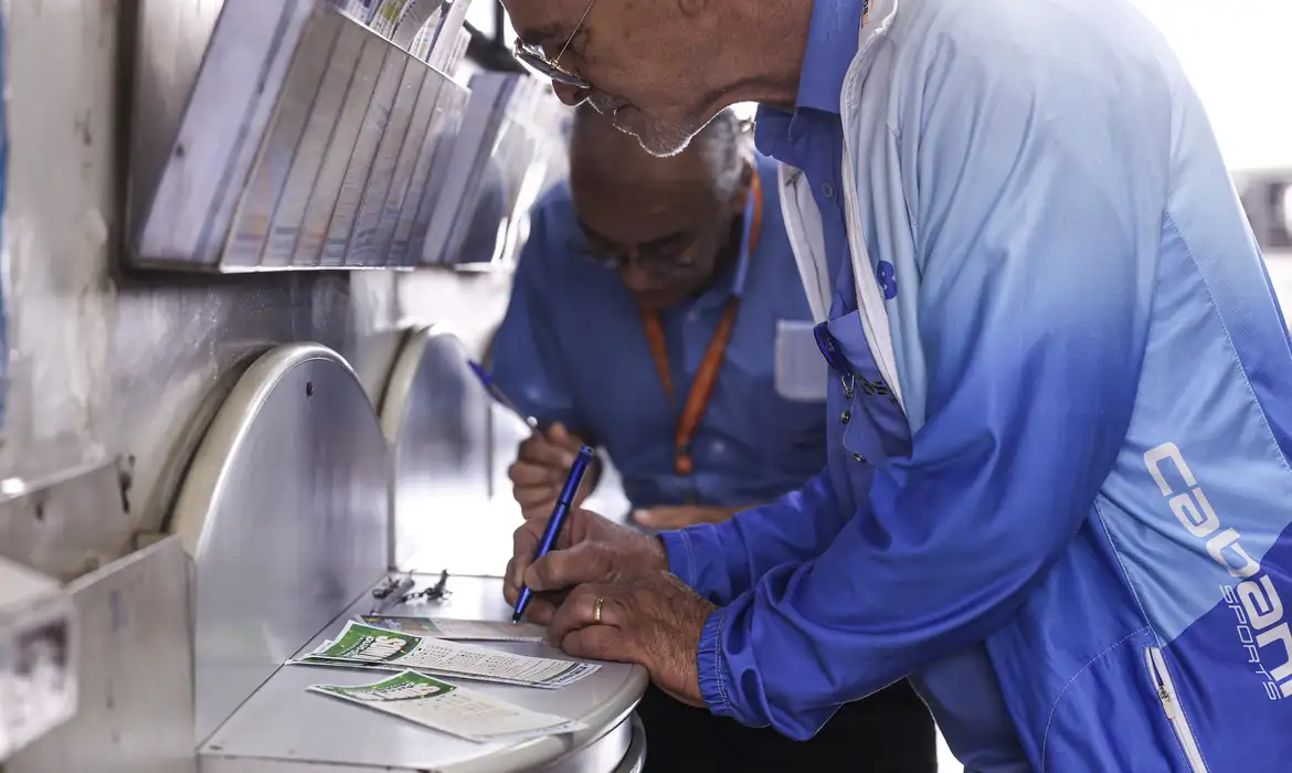 Apostadores preenchem volantes da Mega-Sena em lotérica; foto de arquivo de maio de 2026, não registra o sorteio de outubro.