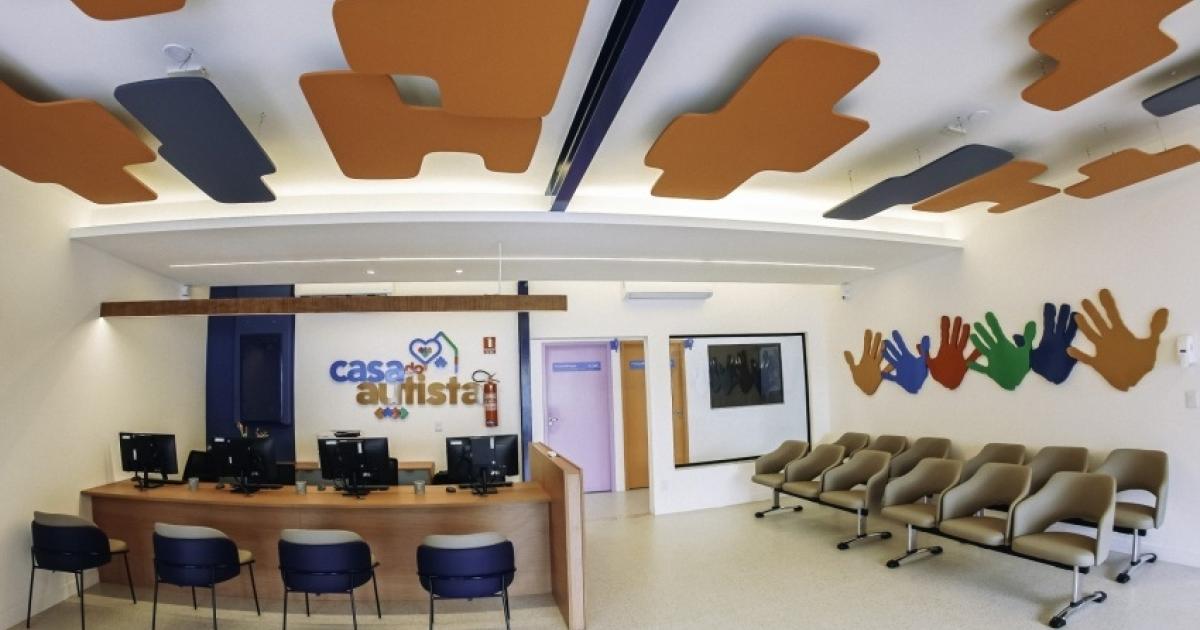 Recepção da Casa do Autista de Maceió, com balcão de atendimento e cadeiras para usuários.