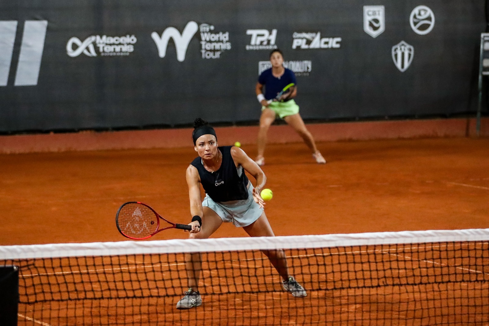 Rebeca Pereira e Bárbara Gatica em ação na quadra de saibro do Maceió Tennis Experience.